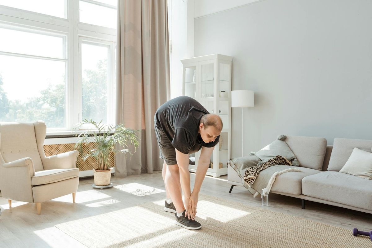 Person doing side stretch in a bright room