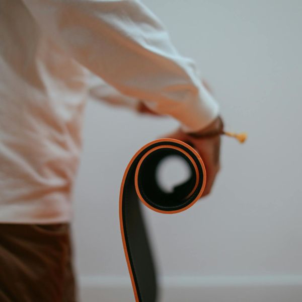 Rolled up yoga mat leaning against a wall